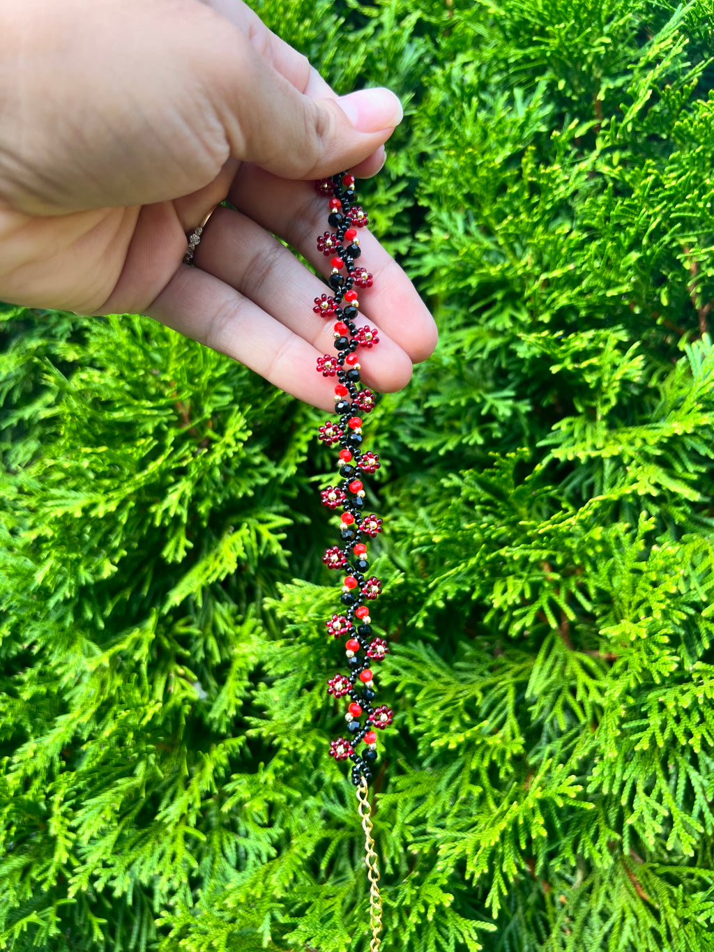 Red and black daisy bracelet with gold accents