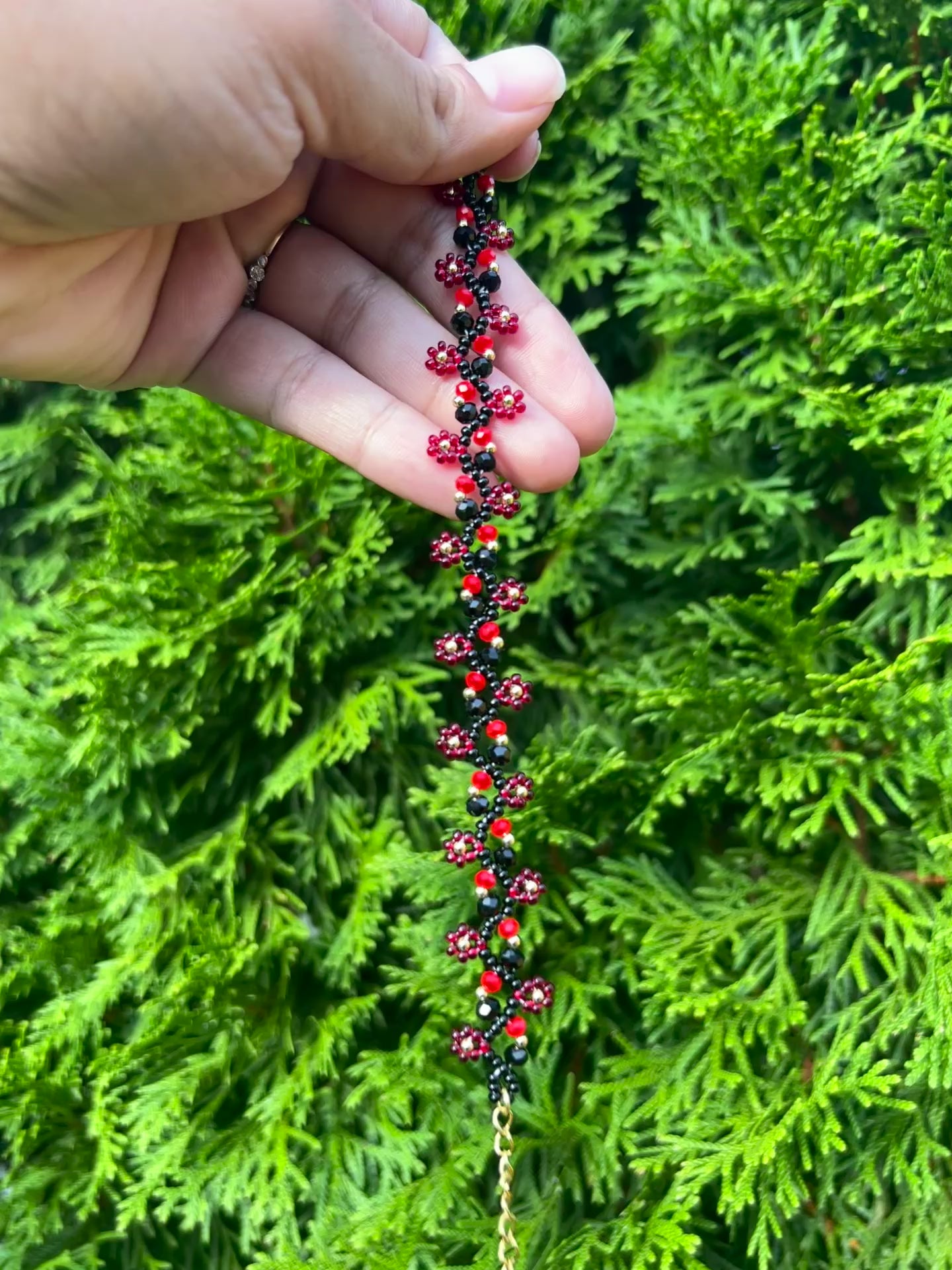 Red and black daisy bracelet with gold accents